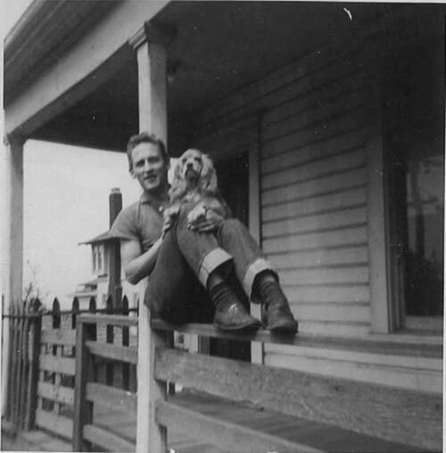 Download the full-sized image of Victor with puppy, named Lady, sitting on a porch