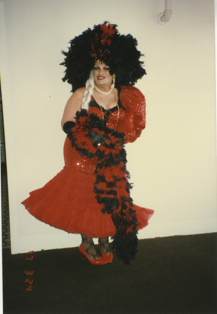 Download the full-sized image of Photograph of Person in Red Feathered Dress with Black Headpiece
