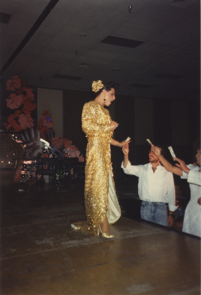 Download the full-sized image of Photograph of Performer in Gold Dress Accepting Cash Tips