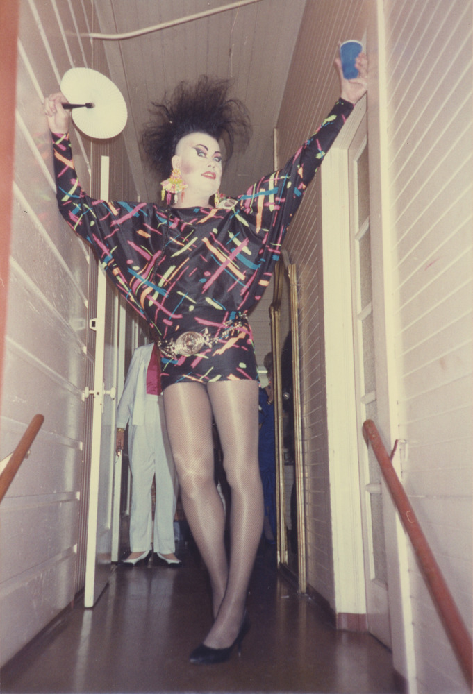 Download the full-sized image of Photograph of Person in Neon and Black Patterned Dress and Fishnets