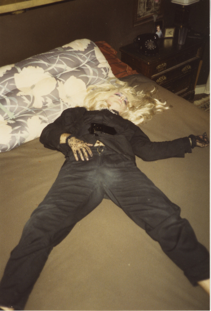 Download the full-sized image of Photograph of Person in Black Outfit and Blonde Hair Laying Down
