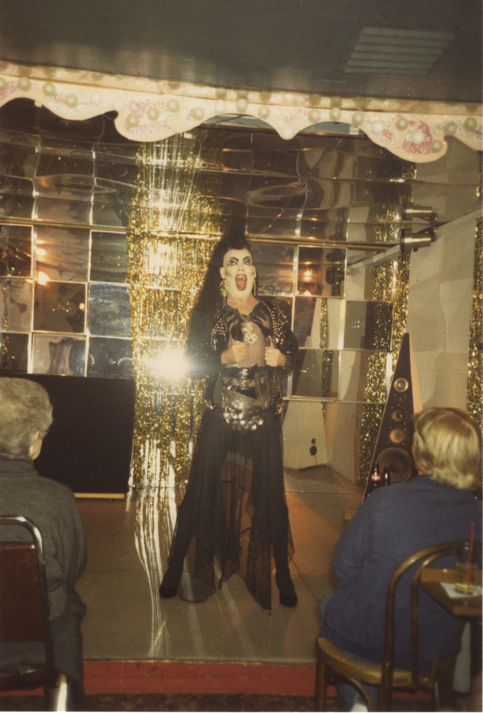 Download the full-sized image of Photograph of Person in Gold and Black Outfit, Yelling Before Audience