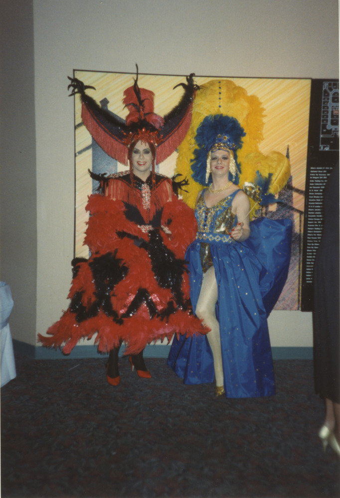 Download the full-sized image of Photograph of Two People in Red and Blue Dresses and Headpieces